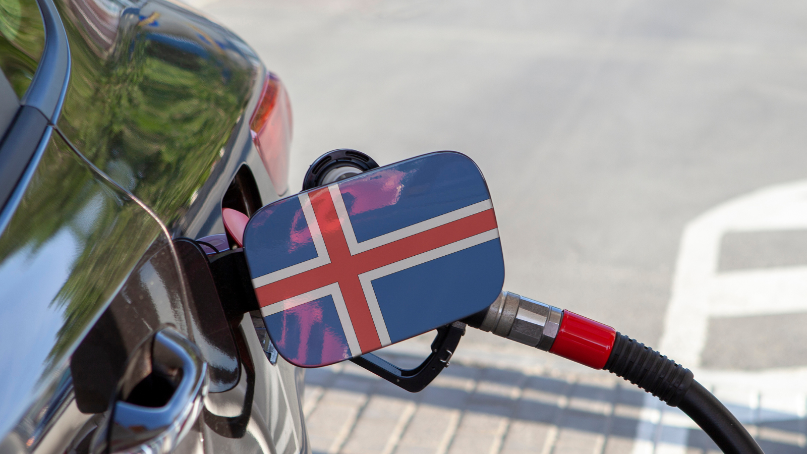 Flag of Iceland on the car's fuel tank flap and pump fueling the car at a gas station