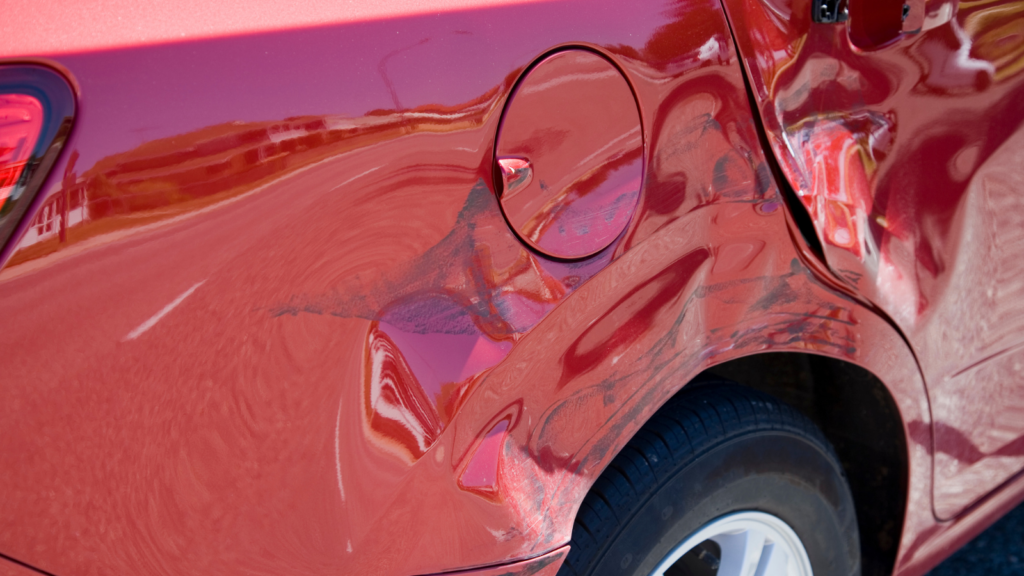 Large scrape down the side of a red car