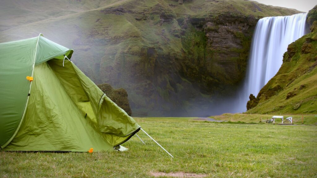 A green tent set up near the Skogafoss waterfall in South Iceland.